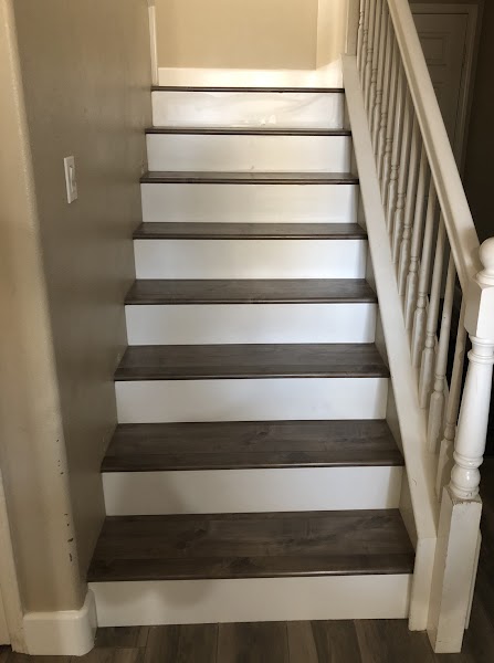Staircase with dark walnut hardwood treads and white painted risers