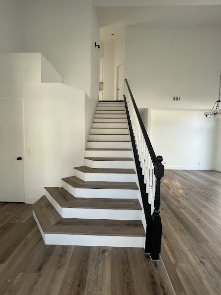 Grand foyer with wide-plank hardwood flooring and sweeping staircase